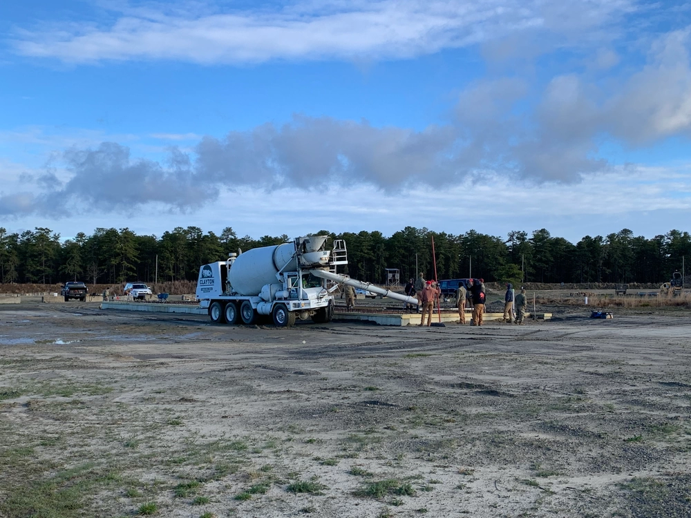 Concrete mixer and crew placing a warehouse floor at Joint Base McGuire–Dix–Lakehurst, New Jersey
